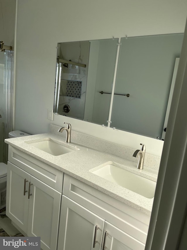 bathroom with walk in shower, vanity, and toilet