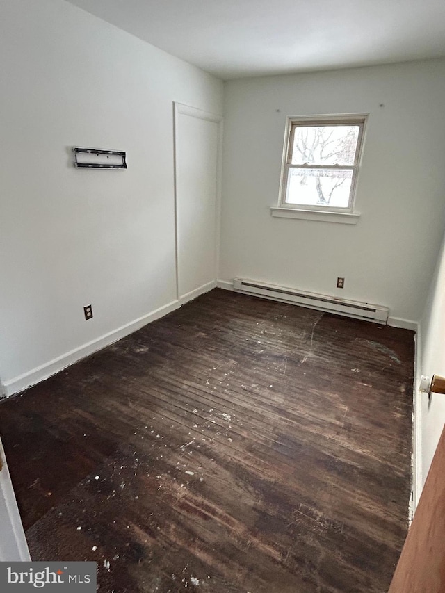 unfurnished room with dark hardwood / wood-style flooring and a baseboard radiator