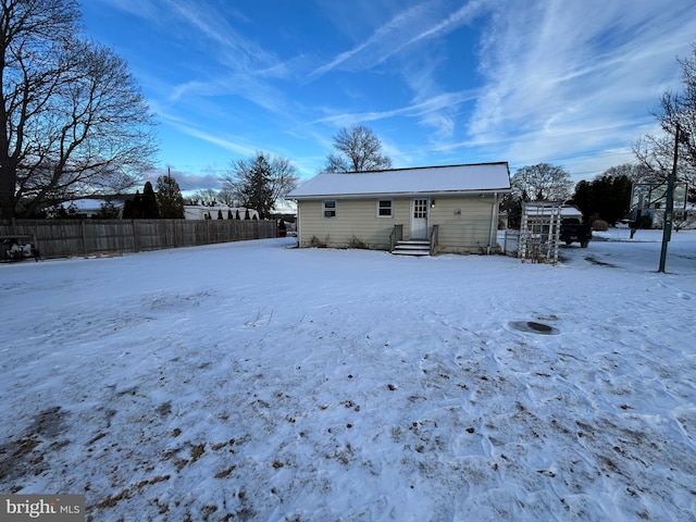 view of snow covered back of property