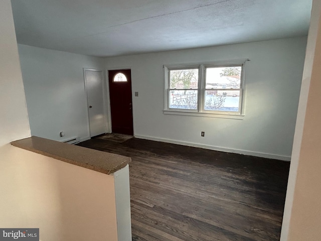 entryway featuring dark wood-type flooring and a baseboard heating unit