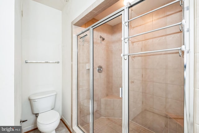 bathroom with an enclosed shower and toilet