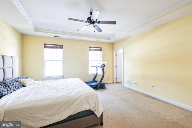 bedroom with ceiling fan, light colored carpet, a tray ceiling, and ornamental molding