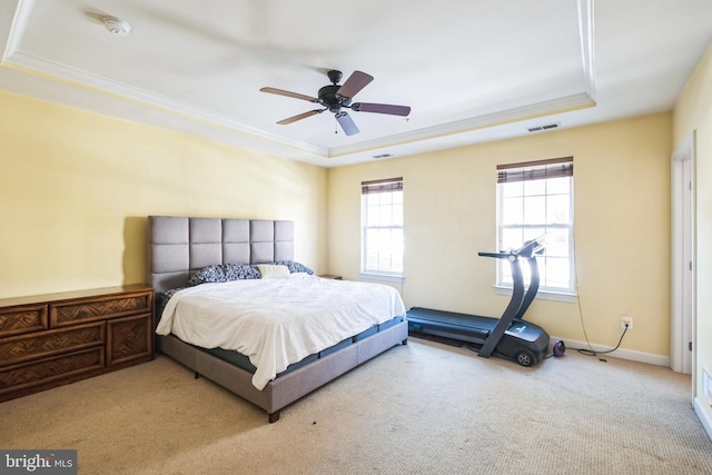 bedroom featuring ceiling fan, light colored carpet, a tray ceiling, and ornamental molding