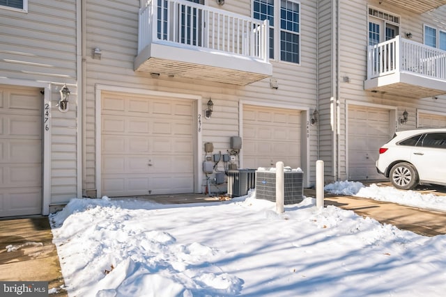 snow covered garage with central AC