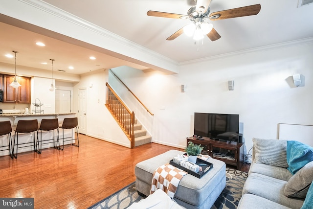 living room with ceiling fan, light hardwood / wood-style flooring, and ornamental molding