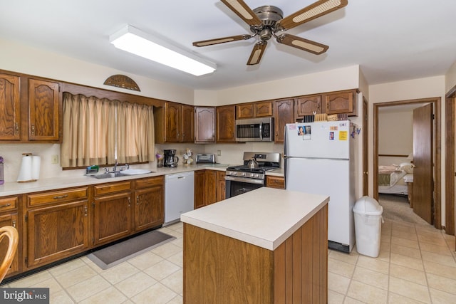 kitchen featuring ceiling fan, sink, a center island, and stainless steel appliances