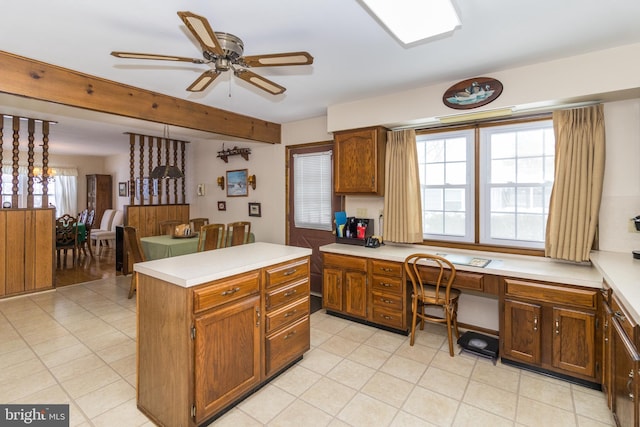 kitchen with ceiling fan, a center island, built in desk, and a healthy amount of sunlight