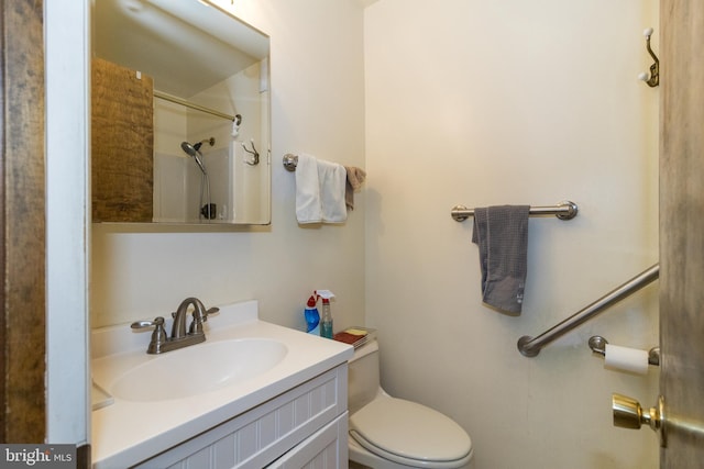 bathroom with vanity, toilet, and a shower