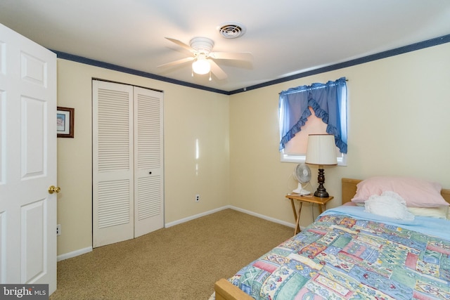 bedroom with carpet flooring, ceiling fan, crown molding, and a closet