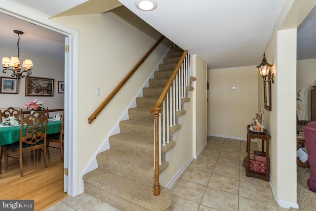 staircase with tile patterned flooring and a chandelier