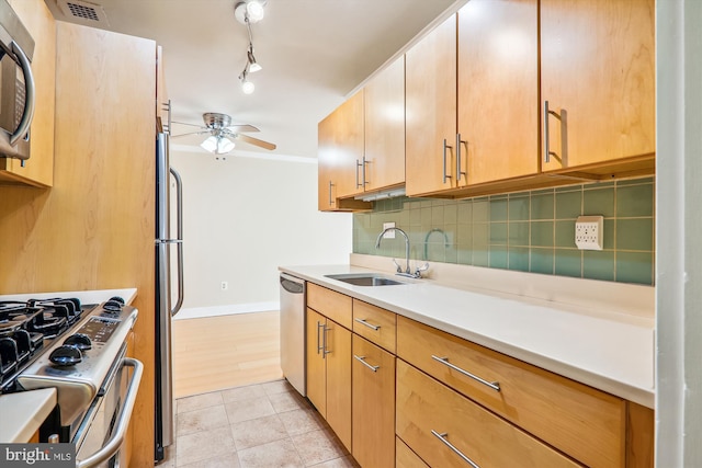 kitchen with ceiling fan, backsplash, appliances with stainless steel finishes, light tile patterned flooring, and sink