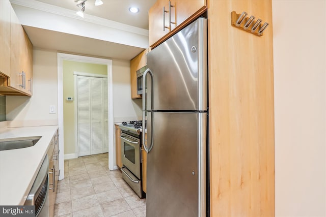 kitchen featuring appliances with stainless steel finishes, crown molding, and sink