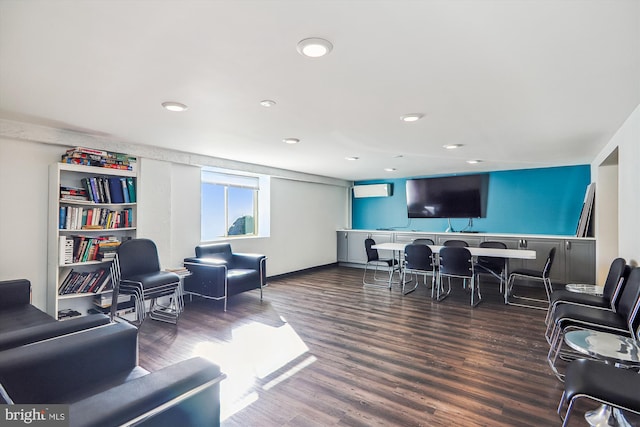 living room featuring a wall unit AC and dark hardwood / wood-style floors