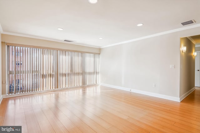 empty room with light wood-type flooring and crown molding