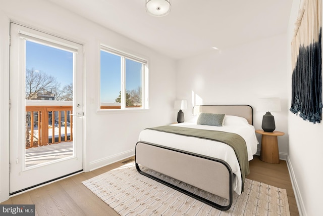 bedroom featuring access to exterior and light hardwood / wood-style floors