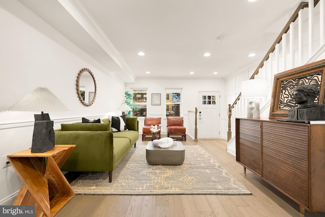 living room featuring ornamental molding and light wood-type flooring