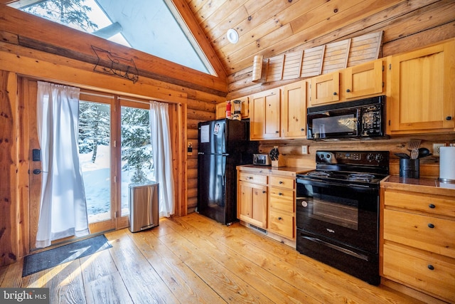 kitchen with light brown cabinets, light hardwood / wood-style floors, a skylight, black appliances, and rustic walls