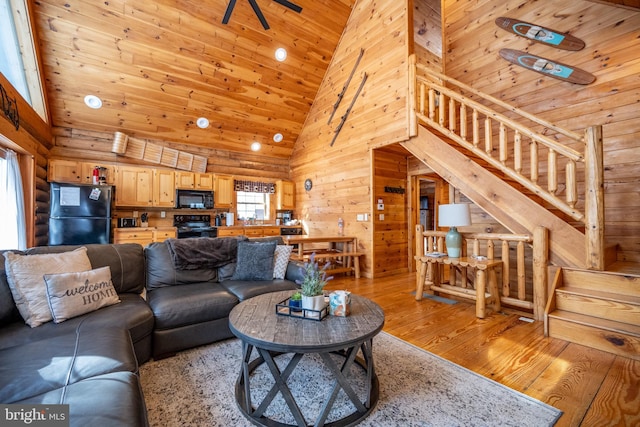 living room featuring light hardwood / wood-style floors, high vaulted ceiling, wood ceiling, and wooden walls