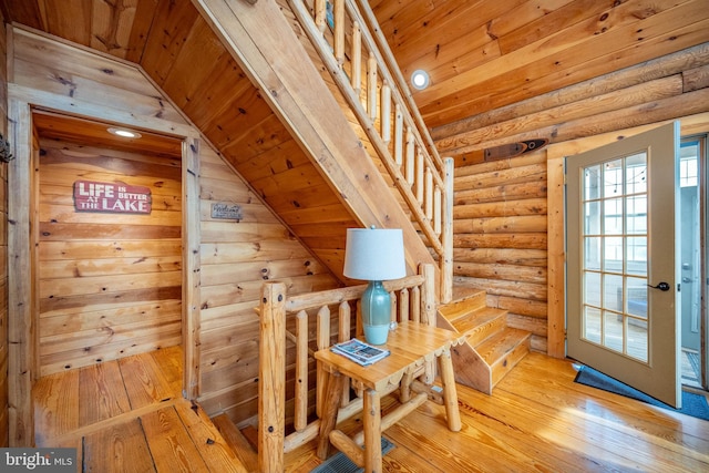 unfurnished room featuring wooden ceiling, light hardwood / wood-style flooring, log walls, and vaulted ceiling