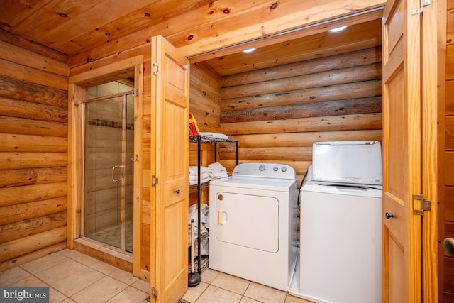 laundry area featuring light tile patterned floors, washer and dryer, and log walls