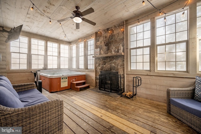 sunroom featuring ceiling fan, wooden ceiling, and a fireplace