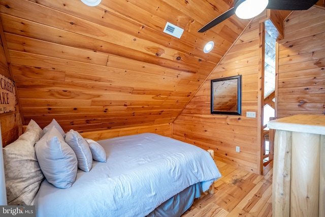 bedroom with wooden ceiling, light hardwood / wood-style flooring, ceiling fan, wood walls, and lofted ceiling