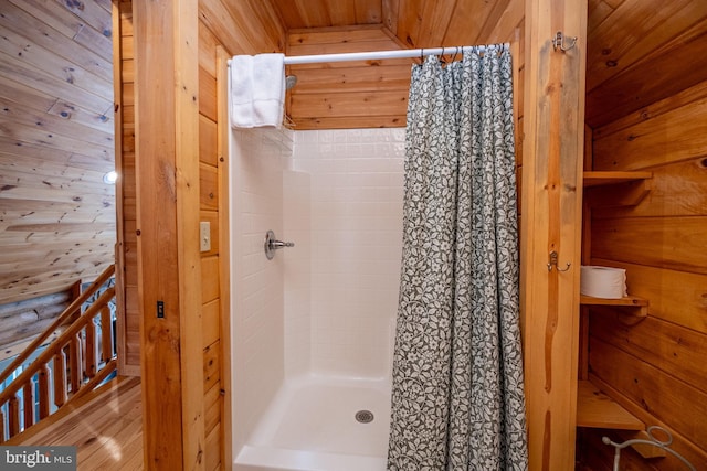 bathroom with a shower with curtain, wooden walls, and wood ceiling