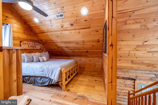 bedroom with wood ceiling, rustic walls, light wood-type flooring, ceiling fan, and lofted ceiling