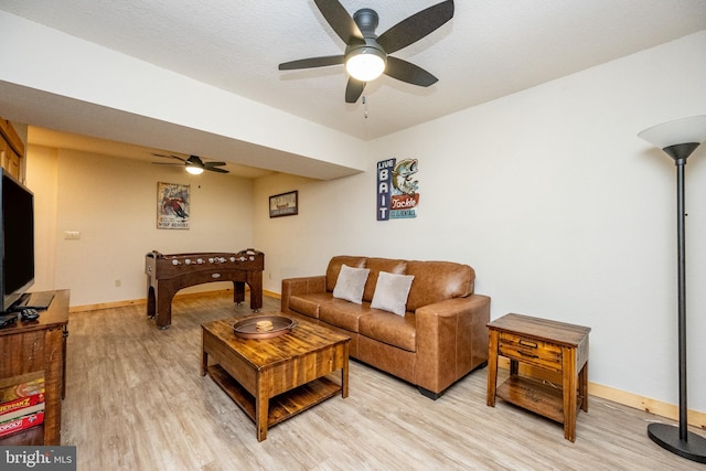 living room with ceiling fan and light hardwood / wood-style flooring