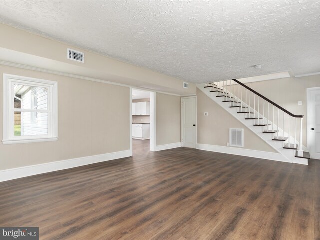 unfurnished living room with dark hardwood / wood-style floors and a textured ceiling