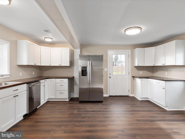 kitchen with white cabinetry, stainless steel appliances, dark hardwood / wood-style floors, and sink