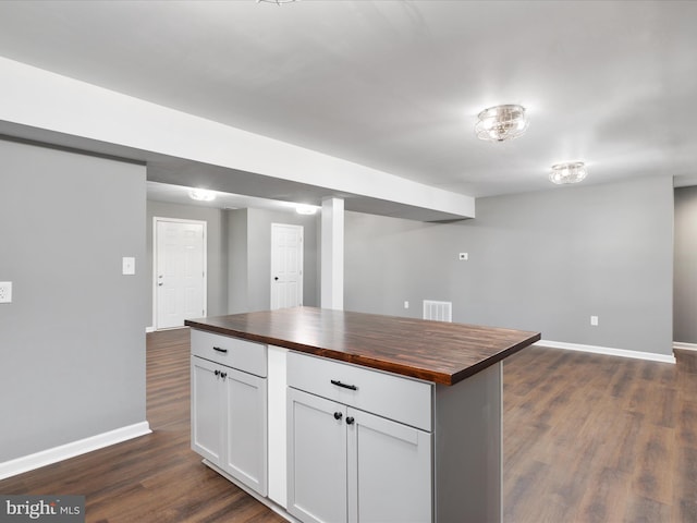 kitchen featuring butcher block counters, white cabinetry, dark wood-type flooring, and a kitchen island