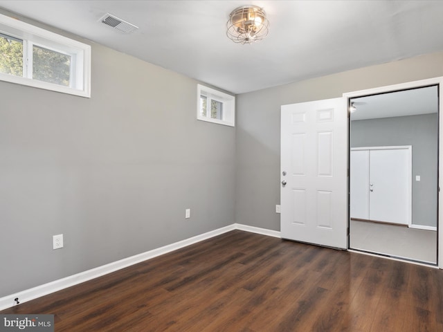 basement featuring dark wood-type flooring and plenty of natural light