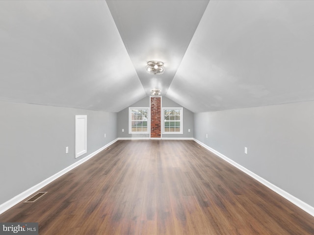 bonus room featuring dark wood-type flooring and vaulted ceiling