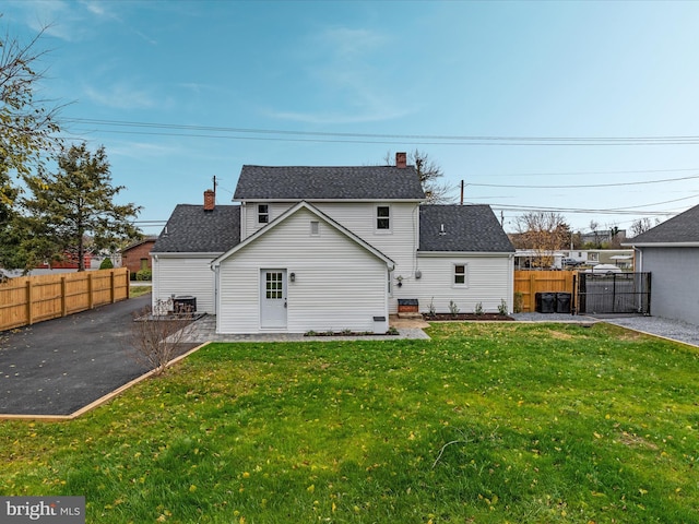 rear view of property with a lawn