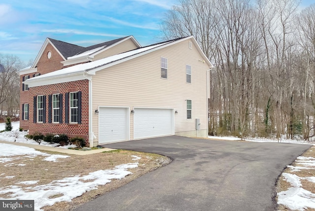 view of snow covered exterior featuring a garage