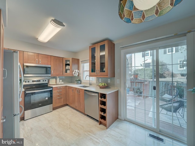 kitchen with appliances with stainless steel finishes, sink, and decorative backsplash