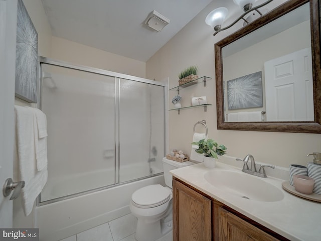 full bathroom featuring tile patterned flooring, bath / shower combo with glass door, vanity, and toilet