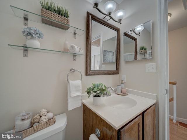 bathroom featuring vanity, wood-type flooring, and toilet