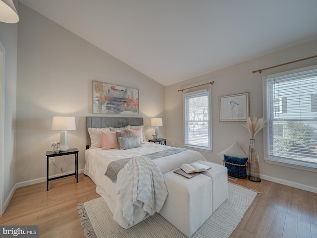 bedroom with lofted ceiling and light wood-type flooring