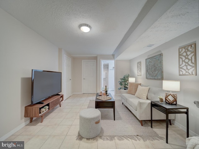 living room with light tile patterned flooring and a textured ceiling