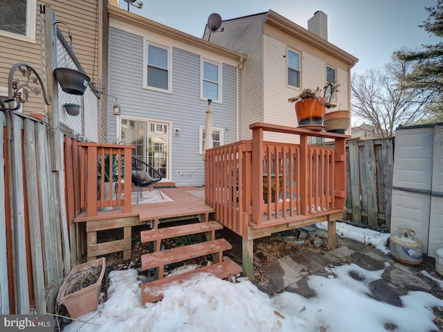 snow covered house with a wooden deck