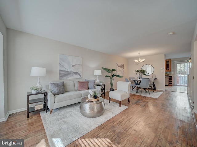 living room with an inviting chandelier and light hardwood / wood-style floors