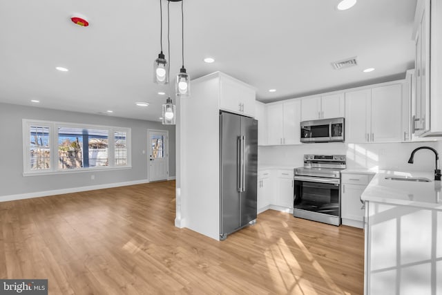 kitchen with sink, tasteful backsplash, light hardwood / wood-style flooring, white cabinets, and appliances with stainless steel finishes