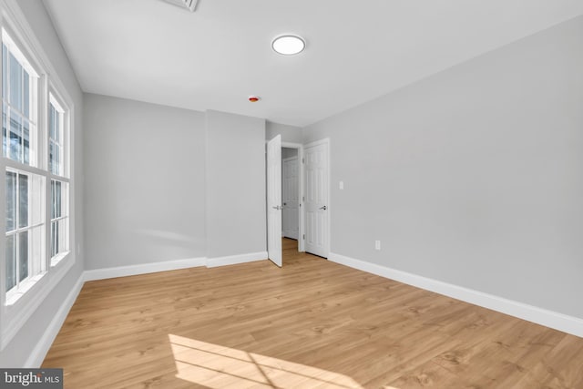 unfurnished bedroom with light hardwood / wood-style flooring and multiple windows