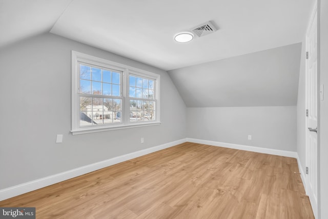 additional living space featuring light hardwood / wood-style flooring and vaulted ceiling