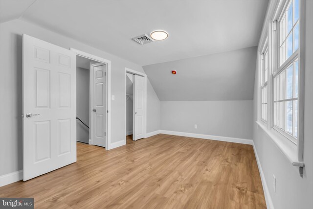 bonus room with light hardwood / wood-style floors and lofted ceiling