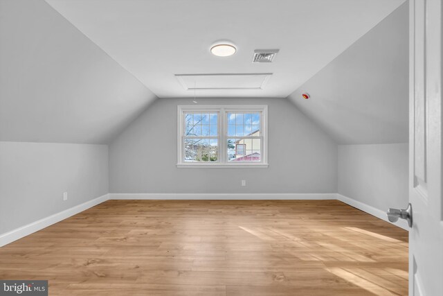 additional living space featuring light hardwood / wood-style flooring and vaulted ceiling