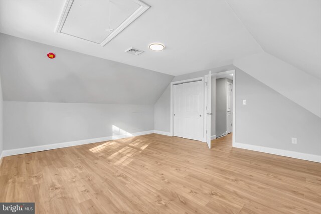 additional living space featuring light hardwood / wood-style flooring and vaulted ceiling