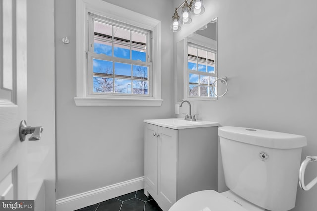 bathroom featuring tile patterned flooring, vanity, and toilet